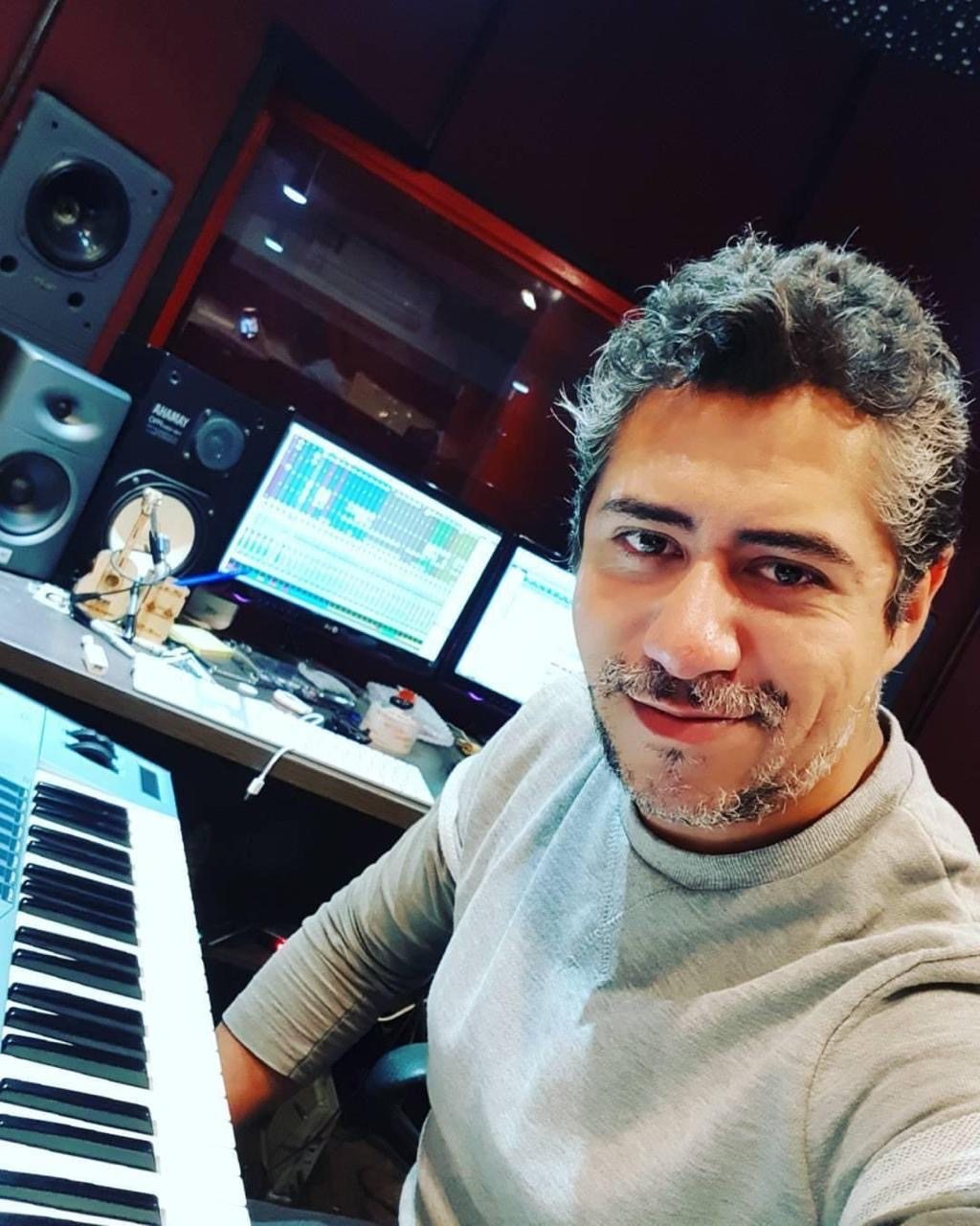 Vitor Alves junto al teclado y los monitores de su estudio